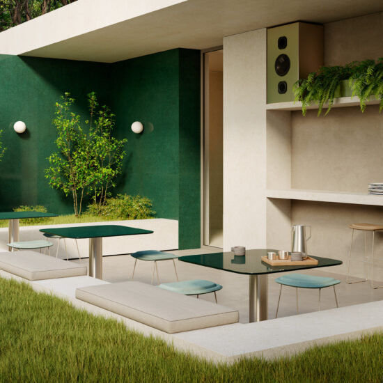 Giardino moderno con divani in tessuto chiaro e tavoli in vetro verde, contornato da piante e pareti in tonalità scura.